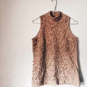  - Linne med halv polo hals i beige från ZARA. Använd fåtal gånger. Cool brodyr på framsida, påminner om blommor. Den har inte faded färg utan jämn färg. 