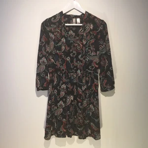  - Superfin paisleymönstrad klänning med knytning i halsen och trekvartslånga ärmar. Dragkedja på sidan där sömmen tyvärr har gått upp precis ovanför (nästan vid armhålan). Enkelt fixat med lite nål och tråd!