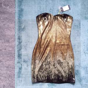 Kort paljettklänning från Nelly
Svart/Guld
Oanvänd med lappar kvar