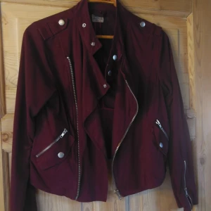  - Snygg vinröd bikerjacka i mockaimitation, litet hål vid kragen baktill, men inget som syns när man har den på sig. Fler bilder kan skickas! 