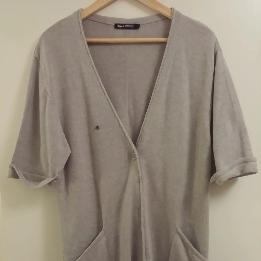 I am size S and it looks fine on me. I wore it over a thin sweater or shirt, even over a mini dress for a casual look.  It is in very good condition, since I wore it a few times only.  Material: 65% merino wool 35% cotton. Stickat.