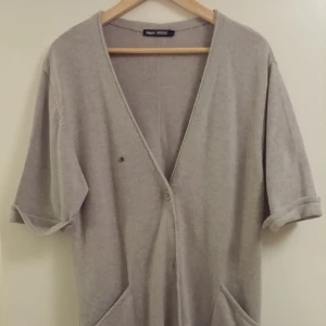  - I am size S and it looks fine on me. I wore it over a thin sweater or shirt, even over a mini dress for a casual look.  It is in very good condition, since I wore it a few times only.  Material: 65% merino wool 35% cotton