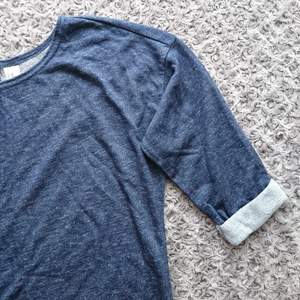 Lätt oversize mörkblå melerad tröja. Lite rundad nedtill och fastsydda uppvikta ärmar till trekvartslängd. Använd ett fåtal gånger, nyskick. 