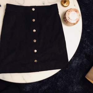 Fin svart fake Mocka kjol med knappar från H&M i storlek 36. Endast använd ett fåtal gånger. Frakt på 45 kr tillkommer. 
