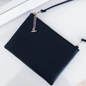  - Svart axelbandsväska i läderimitation med guldiga detaljer. Köpt på H&M. Aldrig använd. Frakt tillkommer med 20 kr. Betalning med swish