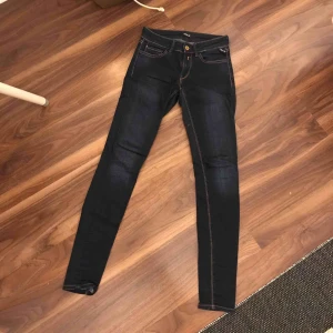  - Näst intill oanvända. Tight (slim)passform, låg modell.  Fint skick, snygg mörkblå tvätt. Märke Replay.  Waist 25, length 32.