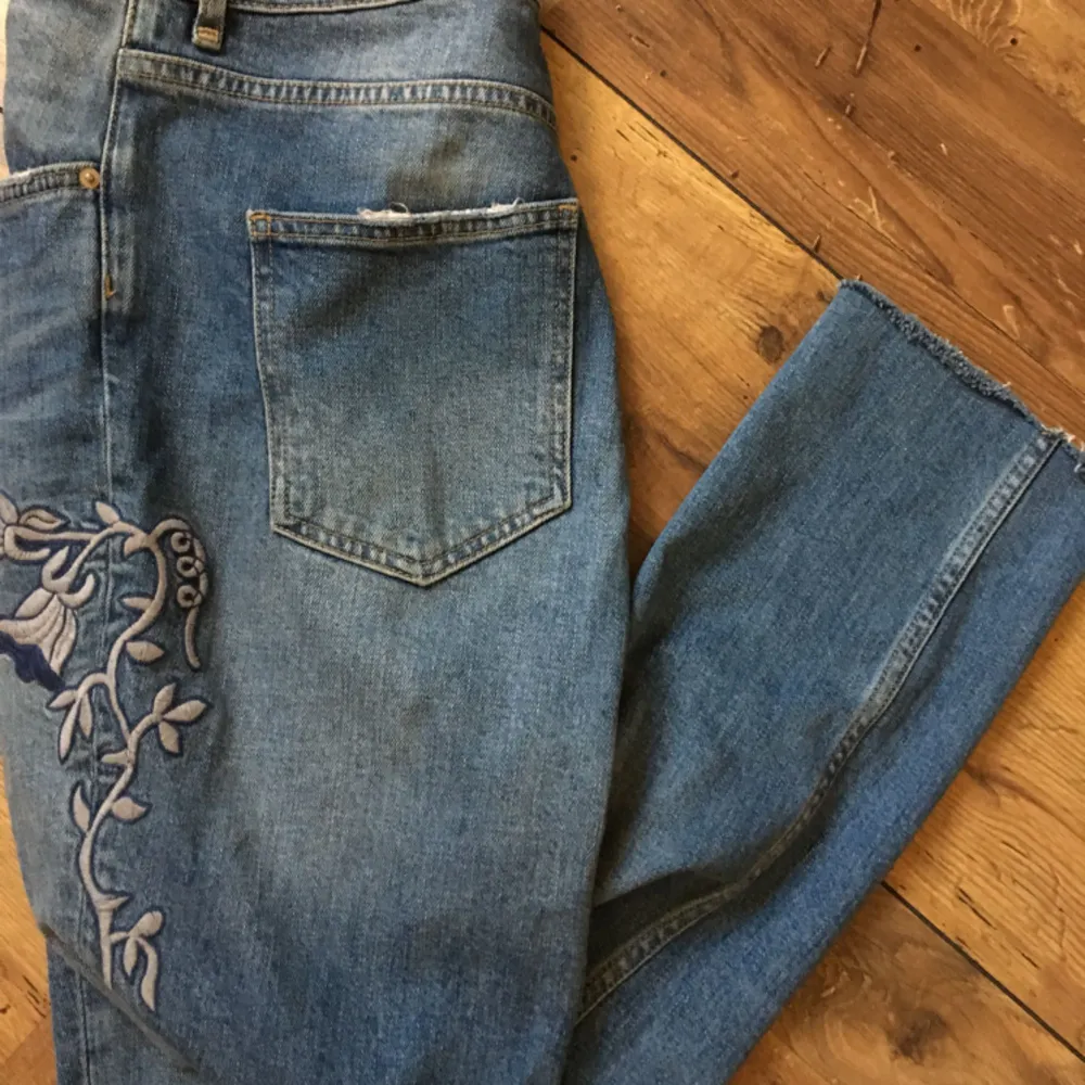 Blåa jeans med fin detalj på ena sidan! Uppklippa nertill! Passar de som har 40-42 i jeansstorlek!. Jeans & Byxor.