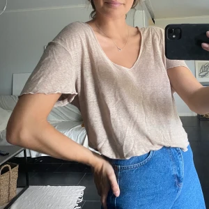 Beige t-shirt - Beige tunn t-shirt från Zara. Något kortare modell och väldigt djup i hals. Frakt tillkommer.