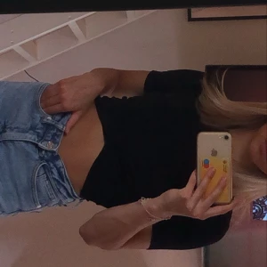 Svart omlott topp - En svart tajt t-shit ifrån hm som tyget går omlott längst ner, helt oanvänd