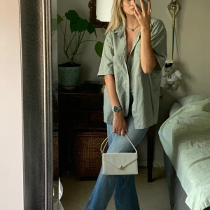 Oversized skjorta - En oversized kortärmad skjorta i en kul grå/blå färg som nästan är lite glansig också, typ som silke. Rekomend, rekomend!