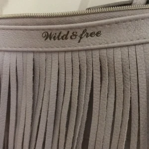 Väska  - Väska med snöre som går ungefär en bit nedanför höfterna på mej som är ca 170 lång. 