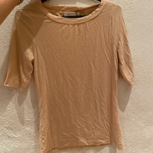 superskön t-shirt från WHYRED - Jätteskön(!!) t shirt från Whyred med längre armar (se bild 2) storlek XS, men fungerar garanterat för en S. 80. Jättefin beige färg. Material:viskos 