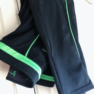Freddy tights strl S - Från FREDDY. Trekvartslånga tights med neongröna detaljer längs midjan och benen. Svart söm baktill för att ge rumpan ett lyft.
