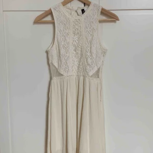  - En lite beige insydd klänning som använts en gång. Spetts upptill och en luftig vid underdel. 