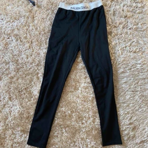  - Svarta leggings, vit kant i midjan med svart text. 