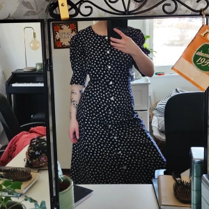 Retro klänning - Mörkblå mönstrad långklänning. Band i ryggen och knappar som detaljer samt axelvaddar (går att ta bort). Ca 70-tal men nyskick! Tyvärr är den för stor för mig. Gratis frakt! 