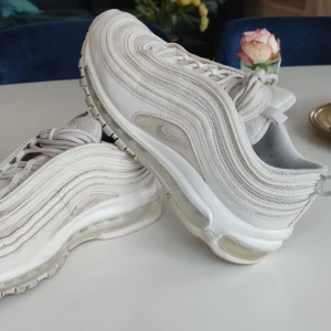 Nike Air Max 97 - Säljer mina snygga 97:or då jag tyvärr ej får användning för dem längre. De vita och har reflex runt om, storlek 38,5 men skulle säga att dem är lite mindre i storleken. Inte alls särskilt slitna, ger dem också gärna en liten tvätt innan de skickas;)