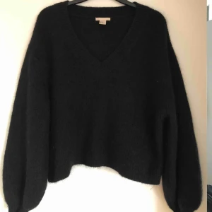  - Svart stickad tröja i mohair från H&M trend. Något kortare modellen med ballongärm. Storlek XS men passar XS-M beroende på önskad passform. Frakt tillkommer. 