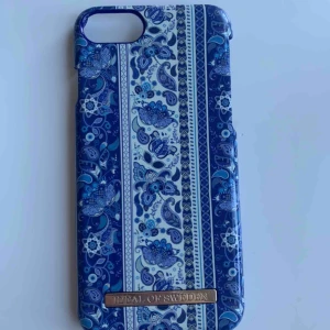  - Blått/vitt skal från Ideal Of Sweden, passar till iPhone 7/8. Där det står ideal Of Sweden har det tappat lite färg (se bild 2) Skriv för prisdiskutering.