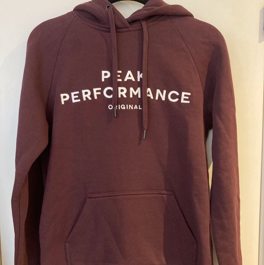 En vinröd hoodie från PeakPerformance med flis på insidan. Färgen syns bäst i första bilden.  Har aldrig använts. 80% bomull, 20% polyester . Huvtröjor & Träningströjor.