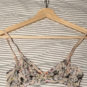 Bh:ar från HM storlek XS/34 - Två bh:ar från hm. Båda i storlek XS. Fint skick! En beige med blommor och en turkos med spetsdetaljer. Säljer båda för 60kr + frakt eller 40kr styck.