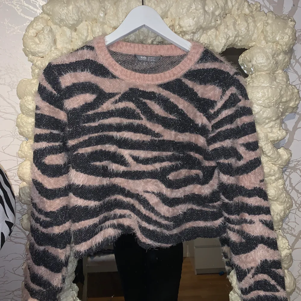 En väldigt Y2k fluffig tröja i rosa/grått/glittrigt zebra mönster, sticks inte alls och har fått en raw hemm av mig själv som gör att det är mer som en crop top, passar en xs-M beroende på önskad passform (strl 158-164). Tröjor & Koftor.