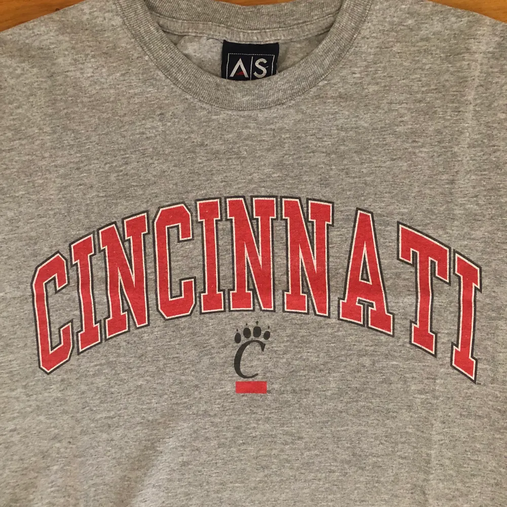 Säljer en riktigt fräsch vintage tröja från Cincinnati University i Ohio. Den är i bra vintage skick från tidigt 00’s och har bara lite cracking i tyget. Den är storlek L men skulle snarare säga att det är en L/M. Undrar du något är det bara att skriva, läs gärna bio innan. Hade det fint!✌🏻🌎. T-shirts.