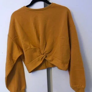 Gul tröja   - Cool gul tröja med knytdetalj från HM. Säljer för att den inte längre kommer till användning. Frakt tillkommer