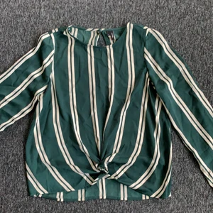 Blus med knyte  - Grön och vit randig blus från Vero Moda. Superfin detalj nedtil