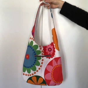 Handgjord färgglad tygväska - En favorit i repris! En handgjord Frida tygpåse i färgglatt tyg, med mörkgrön dragkedjsficka. Går även att vända ut och in för en helvit väska. Pris MED frakt: 195kr 