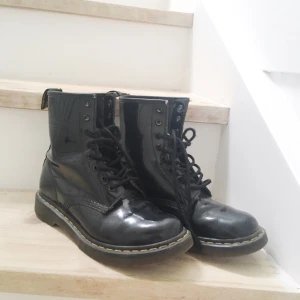  - Svarta glansiga Dr. Martens-kängor i bra skick. Dock är skosnörena något trasiga men dessa brukar gå att köpa separat till bra pris. Priset går att diskutera vid snabb affär. Kan mötas i Borås/Mölnlycke/Göteborg eller skickas mot betalning av frakt🌻