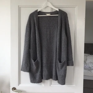  - Mjuk och mysig grå kofta från monki. Perfekt att dra på sig nu på hösten. Den går ner en bit nedanför rumpan på mig som är 169cm. Bra skick.  Köparen betalar frakten!