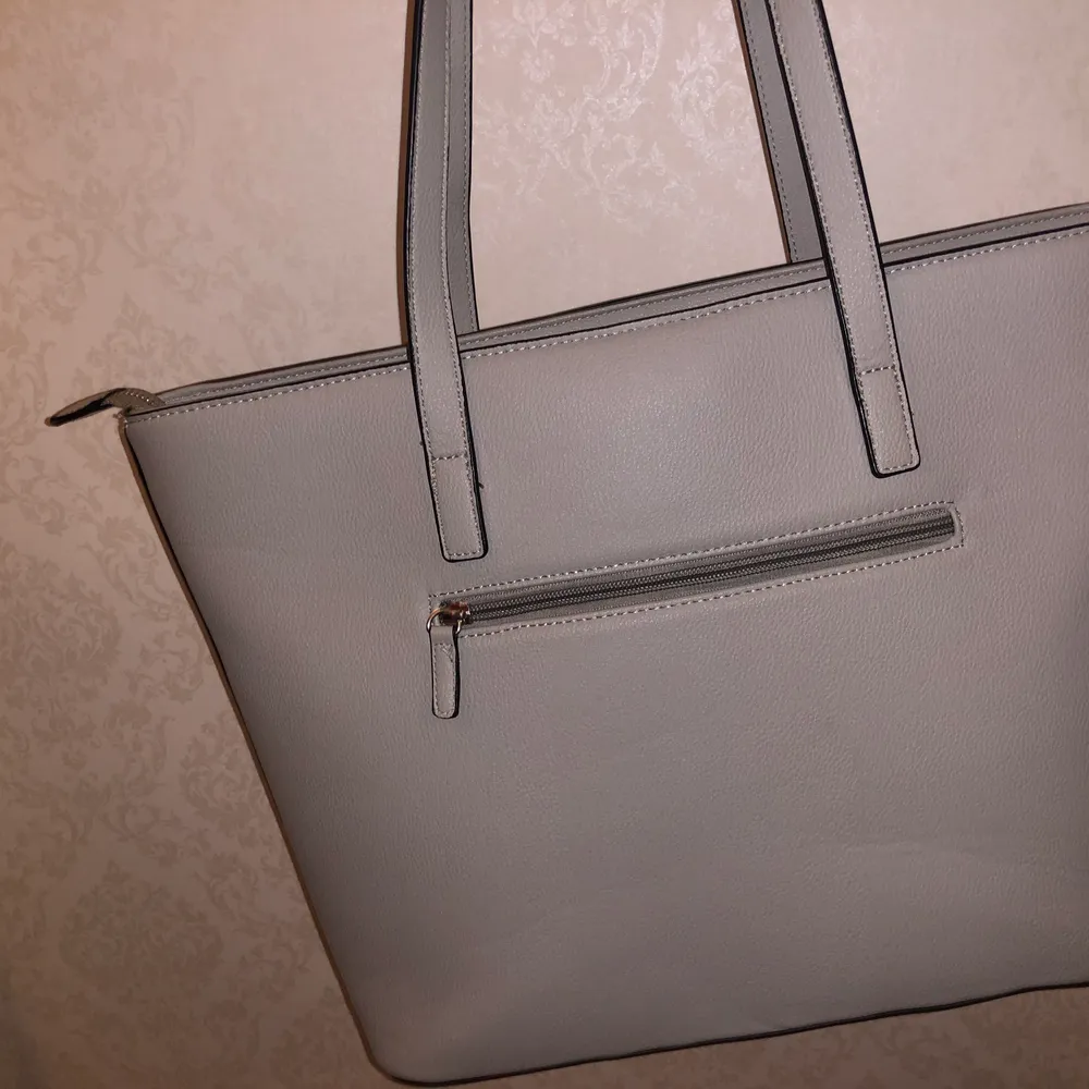 En grå Don Donna väska som har använts Max 4 gånger och har för det mesta legat i min garderob! . Väskor.