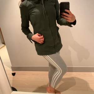 Militärgrön höstjacka - Figursydd militärfärgad höstjacka i tjockt tyg med luva och dragkedja och hög krage som gör att man kan skippa halsduk!