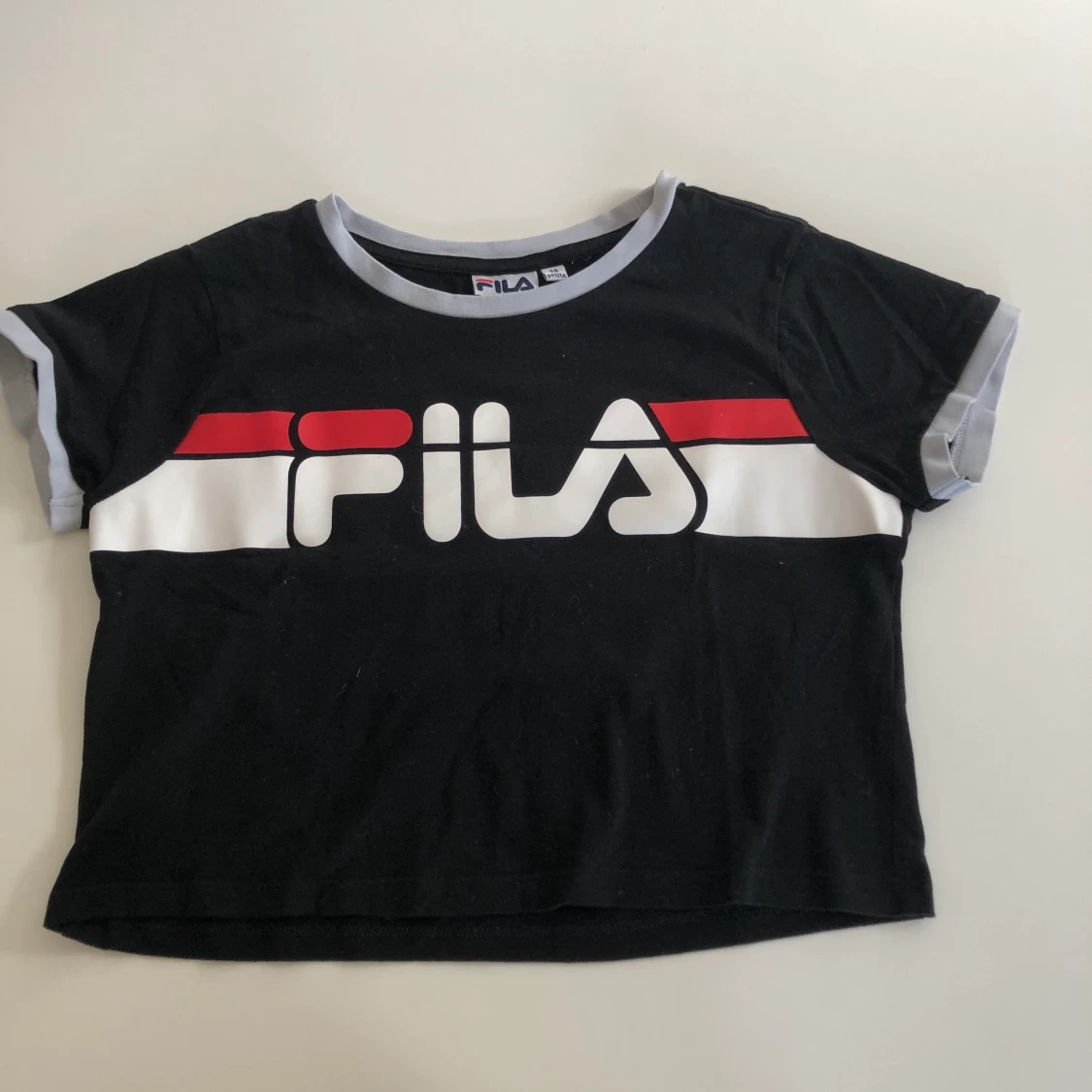 En svart t-shirt med fila tryck