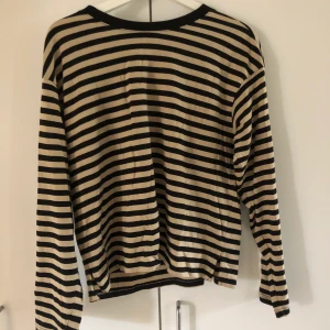 Randig långärmad tröja - En randig långärmad tröja från monki. Färgen är svart o beige. Storlek s men passar både större o mindre storlekar. Köparen står för frakten.