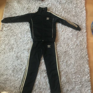 Adidas overall  - Storlek 150 barn. Ganska andvänd som du ser på bild två.benen på byxorna är ganska slitna. Jackan är helt okej