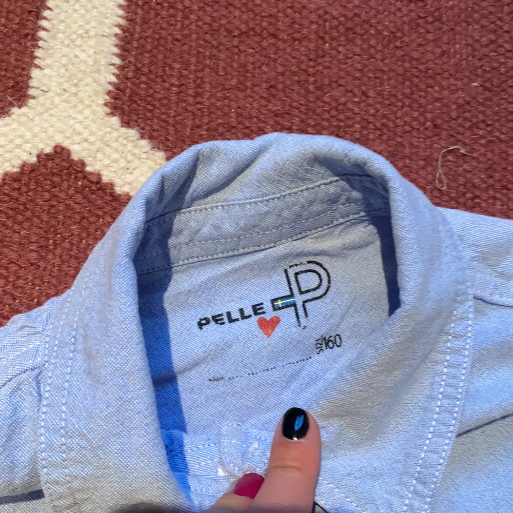 En söt Pelle p skjorta i storlek 160 men är som xs. har en liten lagning men inget man tänker på. Inköpt för 1 år sedan på Pelle p i Dalarö. . Blusar.