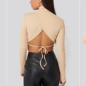 Sååå fin beige body med öppen rygg och hög hals! Den är verkligen inte alls mycket använd, kanske max 5 gånger. Köpt från NA-KD för 350 kr. Kan skicka egna bilder om så önskas🥰 Köparen står för frakten💜