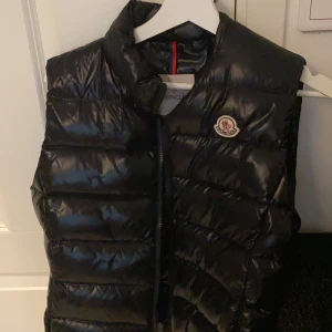 Äkta Moncler väst - Storlek: 8 (passar S och M), köpt för 6 månader sedan på NK, passar ej mig därför jag säljer den. Glansig modell, köpt för 5500kr. 