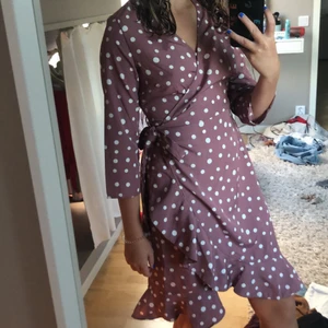 Söt Vero Moda klänning  - Supersöt prickig omlottklänning i lila/rosa nyans. Klänningen är knytbar i midjan beroende hur tajt man vill ha den. Kommer inte till användning då jag har en likadan i grön💞