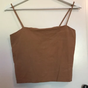 Beige/brun topp från Ginatricot i strl M - Fin beige/brun topp som går ovanför naveln från Ginatricot i strl M. Toppen är i bra skick!