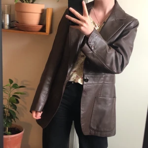 Mörkbrun oversized skinnjacka - Köptes på Bonbon’s first and secondhand i Berlin förra året för 1200kr. Jättefint skick! Står ingen storlek men skulle säga unisex storlek M