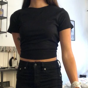 Svart ribbad tshirt - En svart ribbad tshirt som är aningen kortare. 50 kr + frakt