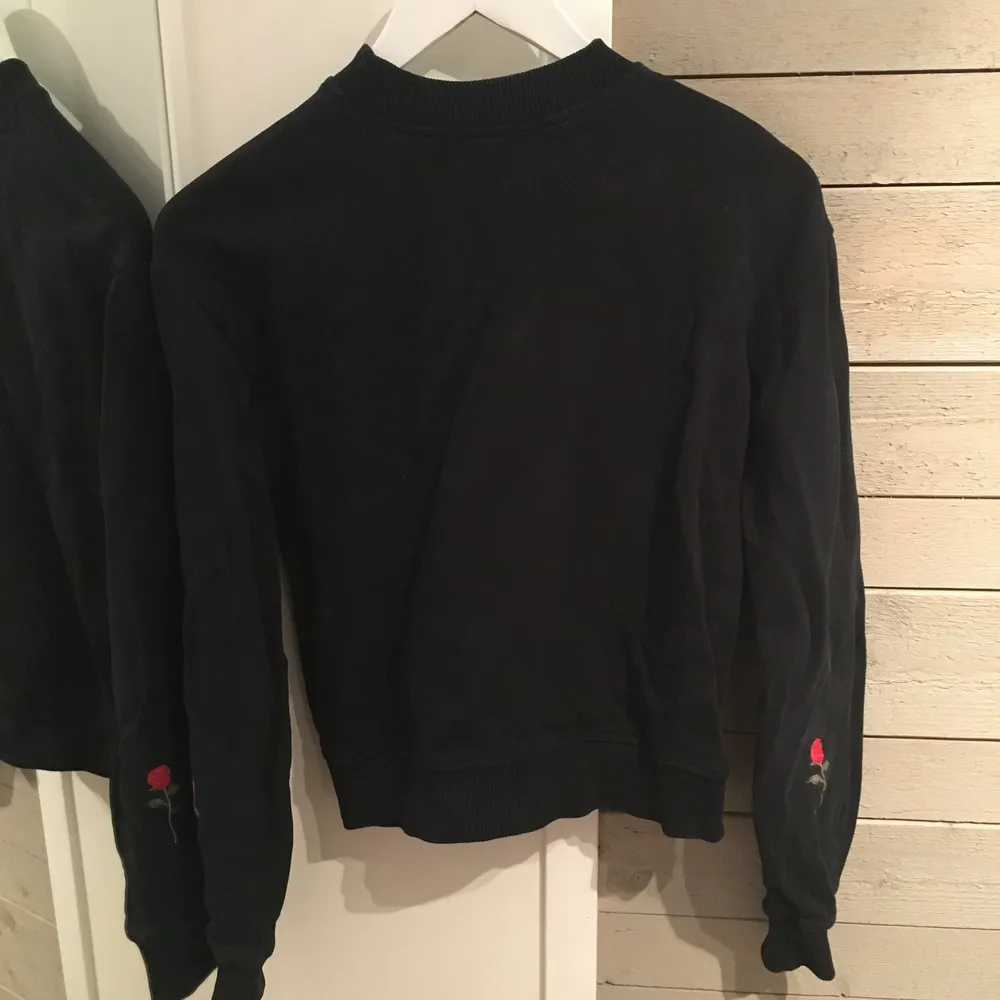 Basic svart sweatshirt med rosor på baksidan av underarmarna. Väldigt fin och bra skick men har inte kommit till användning på länge och är för liten för mig. Passar XS eller XXS. Katt finns i hemmet. 90kr + frakt.☺️. Tröjor & Koftor.