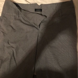 TVÅ PAR RUTIGA BYXOR  - två par rutiga kostymbyxor i storlek 40. Säljs tillsammans. Hund och katt finns i hemmet. 