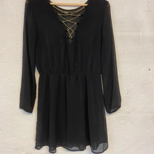 Bik Bok klänning - Svart klänningen ifrån Bik Bok med guldkedja vid bröstet. Använd ett fåtal gånger och den är i storlek M. Säljer för 80kr + frakt.