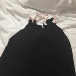 Tröja  - Ett svar linne med rosa snören. 8