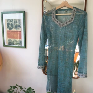  - Kanske den vackraste klänningen i världshistorien!! Perfekt skick, storlek är inte angiven men uppskattas till S-M. Klänningen har vackra handbroderade detaljer och slits i båda sidorna.