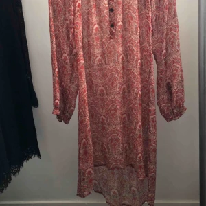  - Knälång, långärmad klänning från Fira. Krävs en underklänning till pga att den är genomskinlig. Passar XS-M Köparen står för ev frakt.